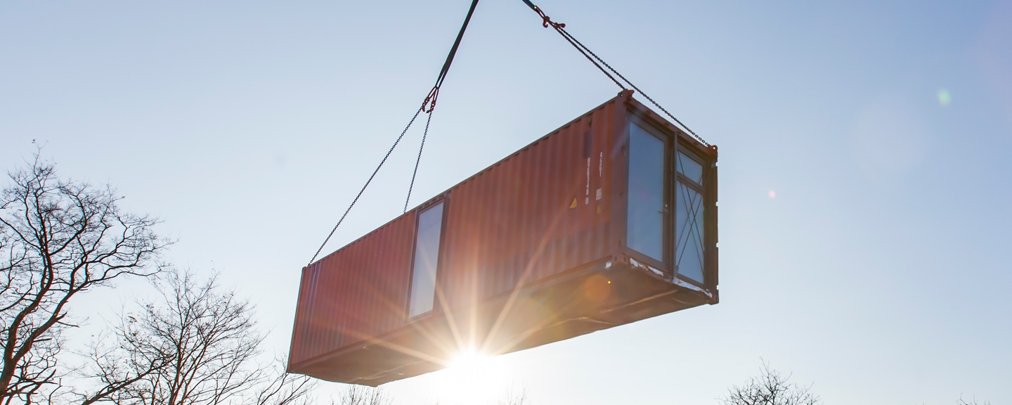 Containermodul wird per Kran versetzt